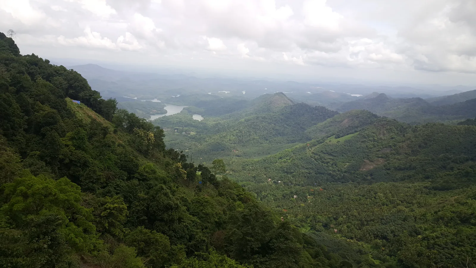 Lush forested hills and blue-green water at Kakkayam, Kozhikode